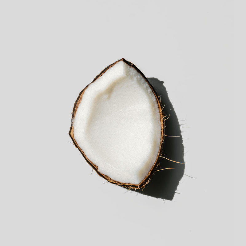 Half-cut coconut on a light gray background